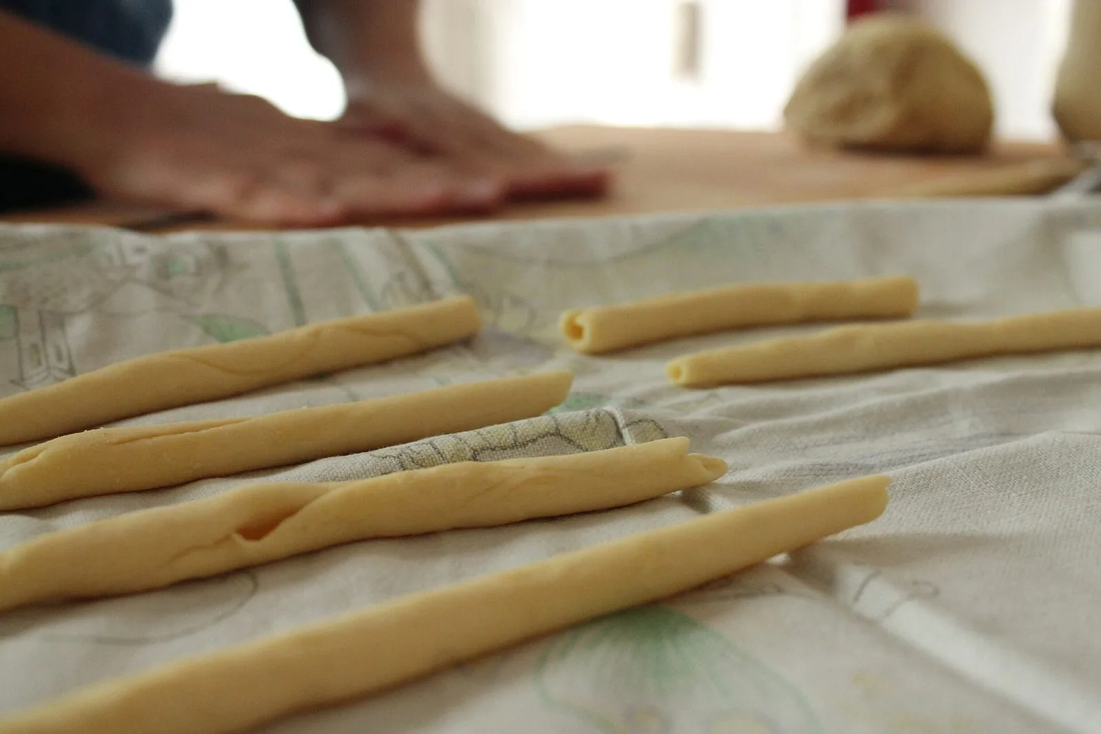 Pasta fresca cilentana lavorata a mano col ferretto, allineata su un piano infarinato