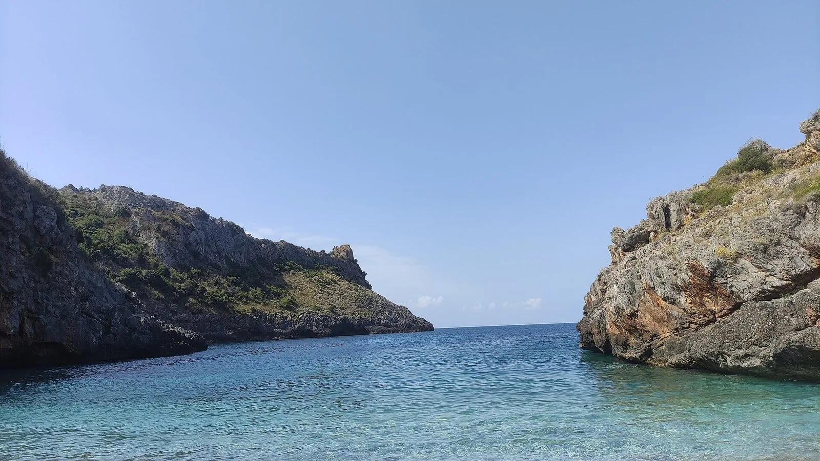 Spiaggia sabbiosa della costa cilentana in estate, con la pineta alle spalle e il mare calmo del Golfo di Salerno